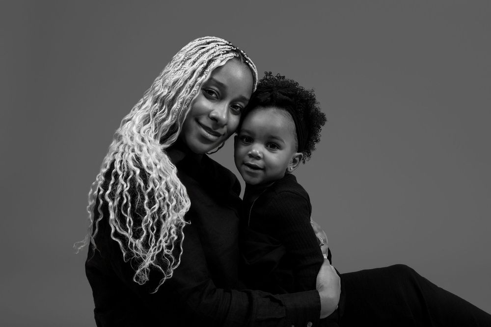 Intimate black and white portrait of parent and child embracing.