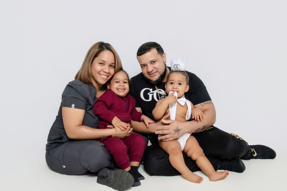 Family of four poses together on white studio background.