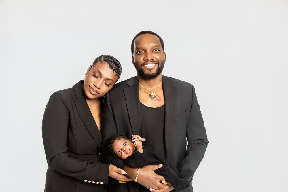 Intimate family portrait with parents in black formal attire.