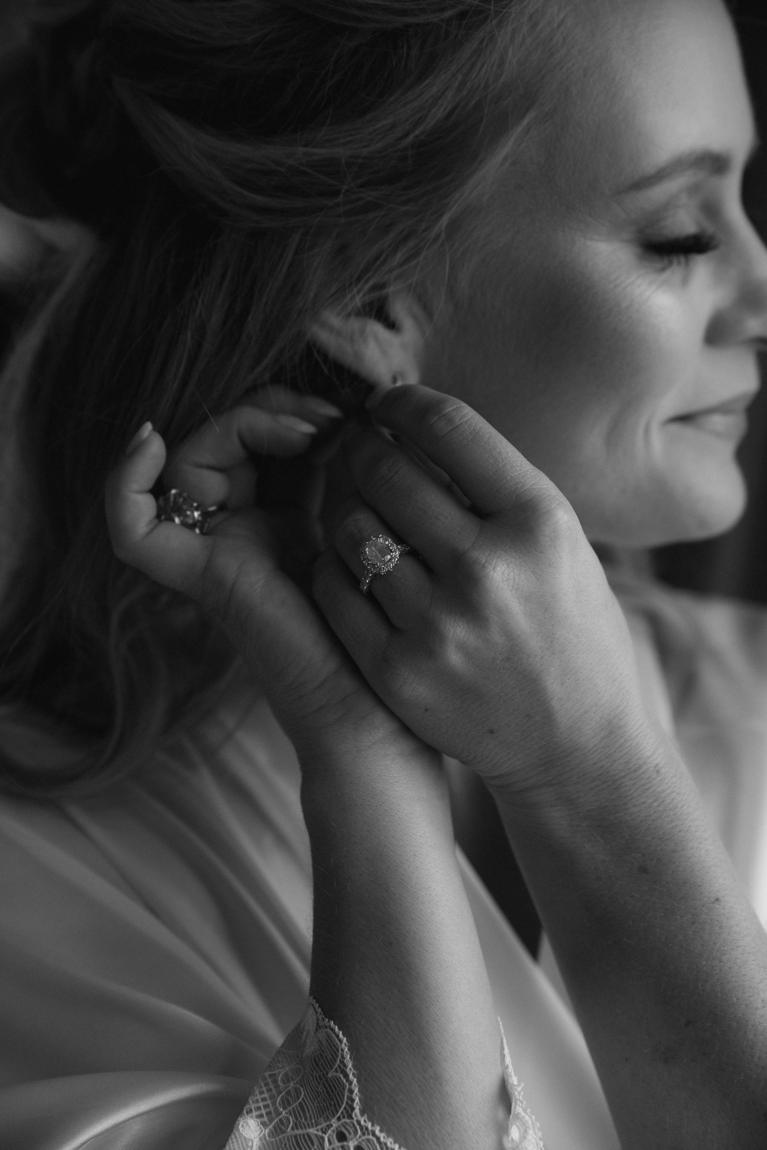 Close-up artistic black and white photo showing jewelry and hands.