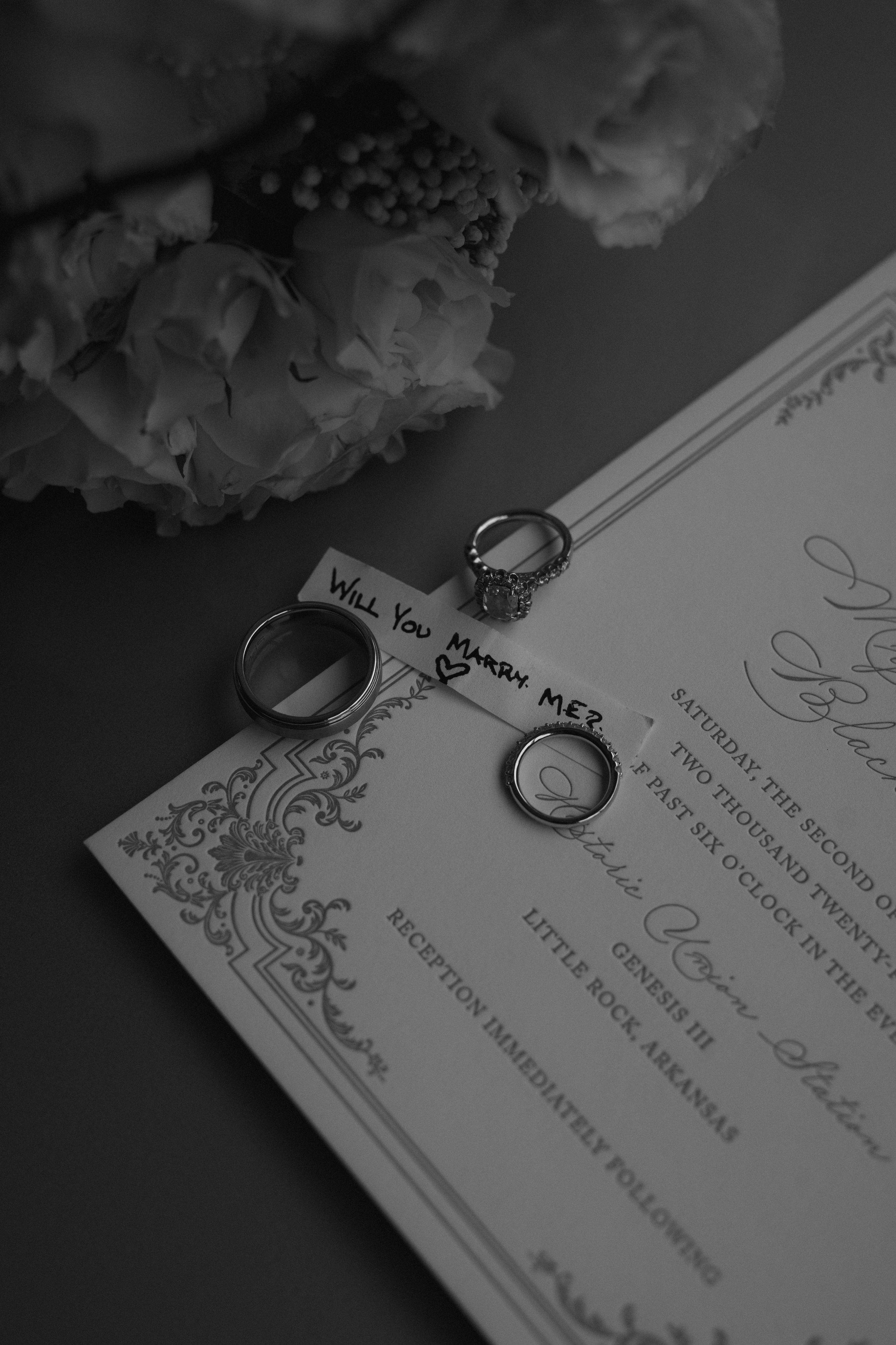 Wedding rings rest on an ornate marriage certificate with floral decorations.
