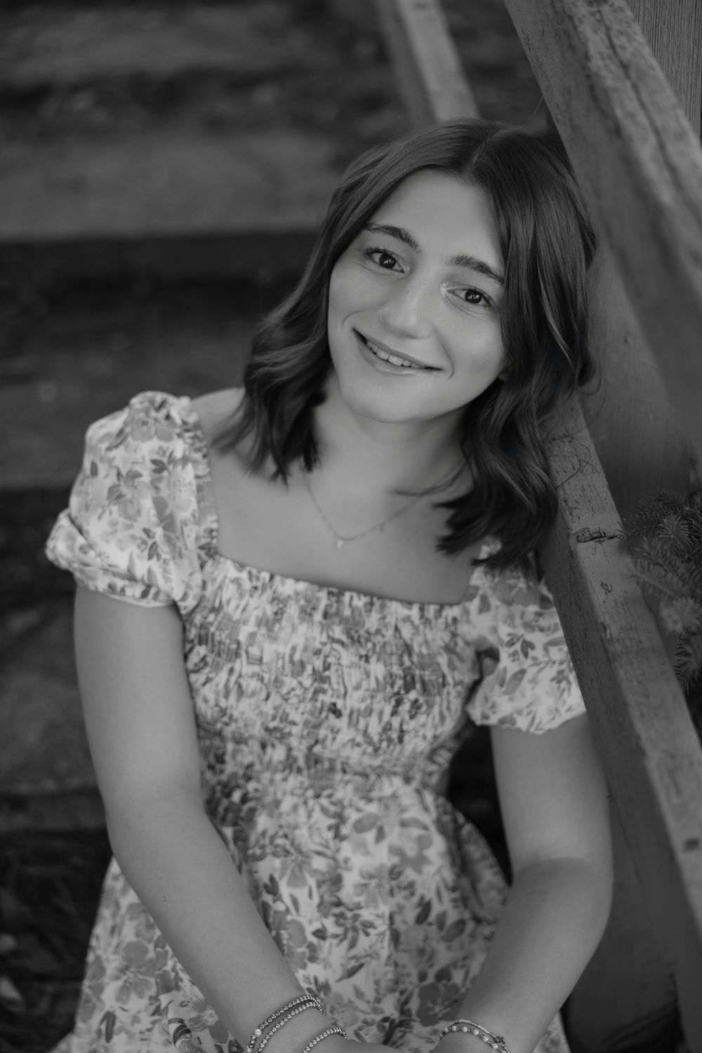 A series of black and white portraits showing someone wearing a floral dress with puff sleeves in different poses.