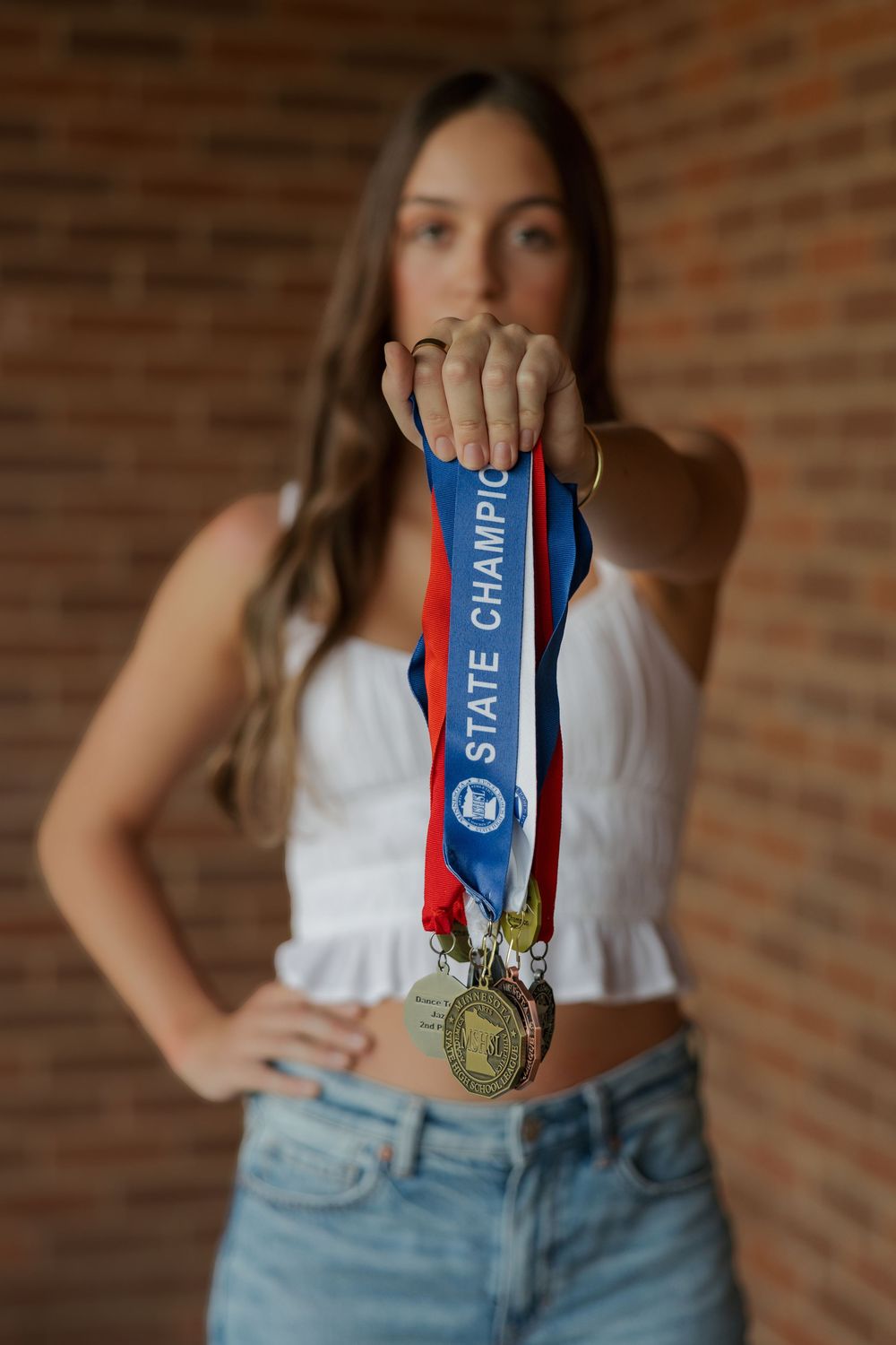 A series of photos showing a patriotic red, white and blue medal with ribbons displayed against light denim clothing.