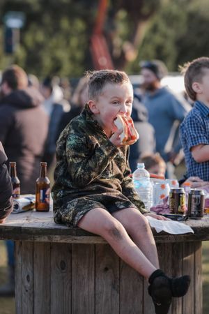 kid stuffing his face with food at hunting competition in rural Canterbury