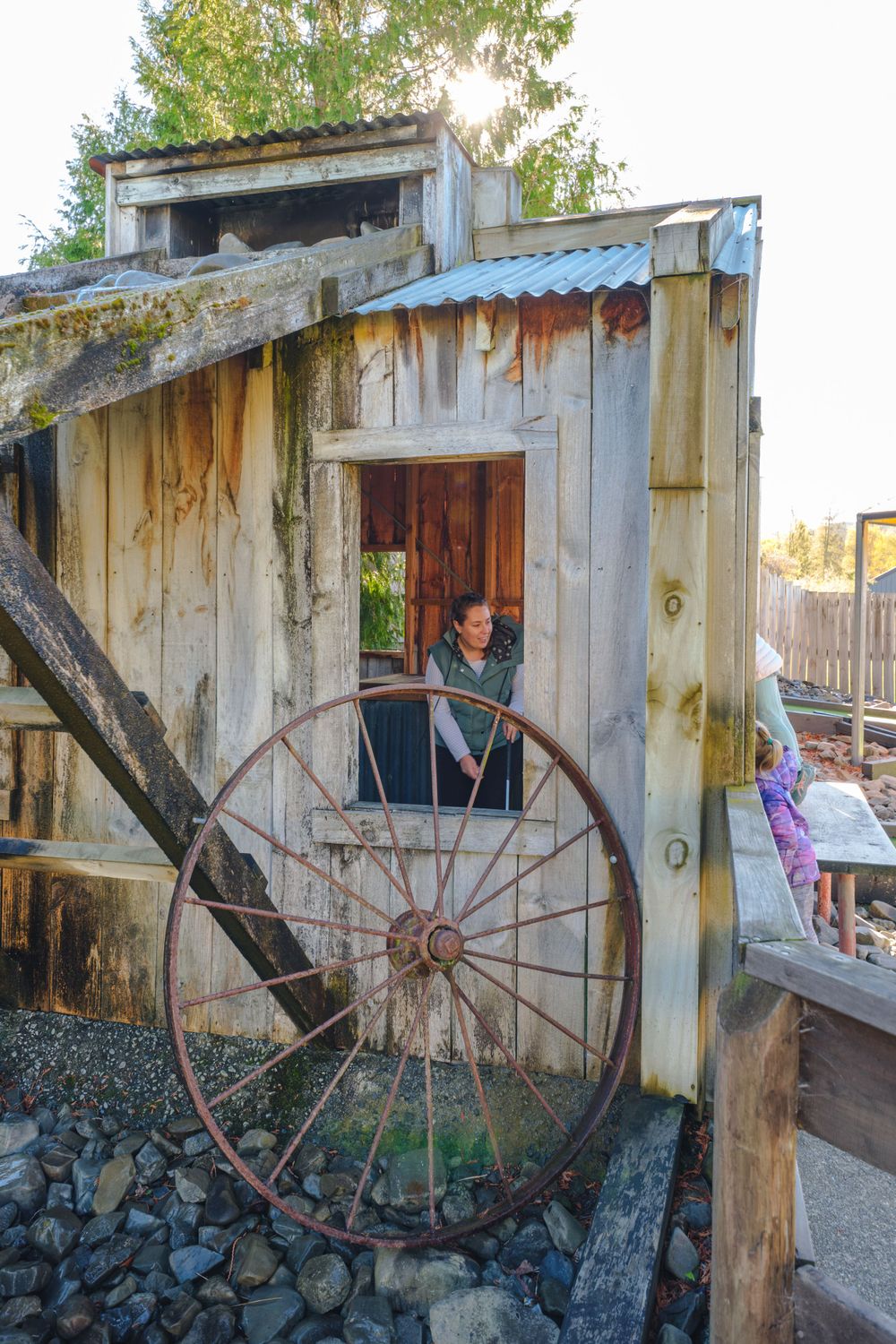 Rustic wooden structure with vintage wagon wheel decorations at mini golf course.