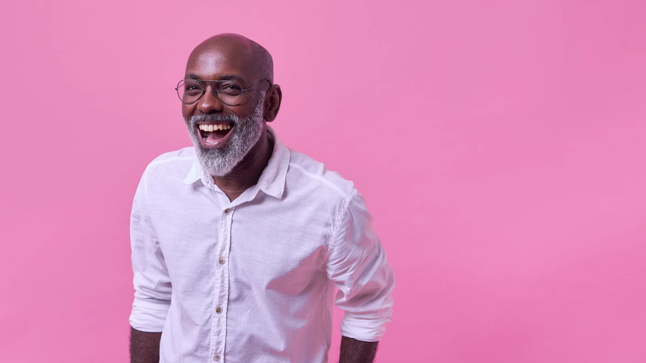 A Happy black man with white shirt having a white beard and on glasses
