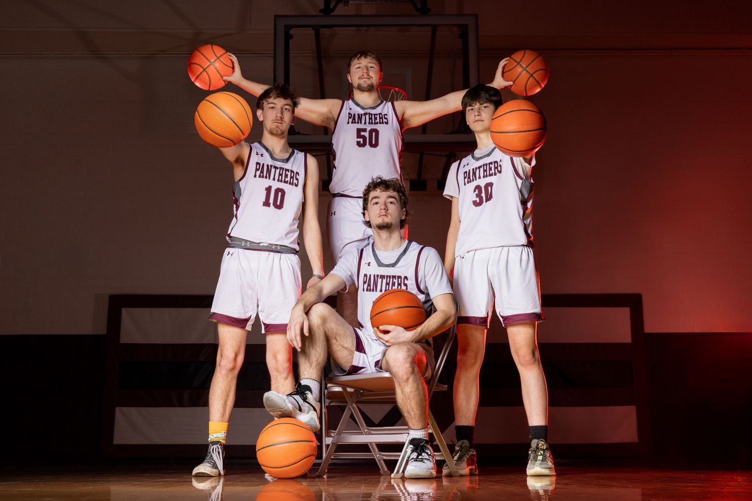 A small basketball group poses for a sharp, confident portrait session, showcasing unity and team pride with focused expressions.