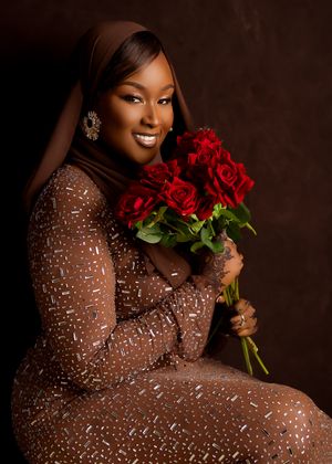 Glamorous portrait with sparkling sequined dress and vibrant red roses against dark brown background.