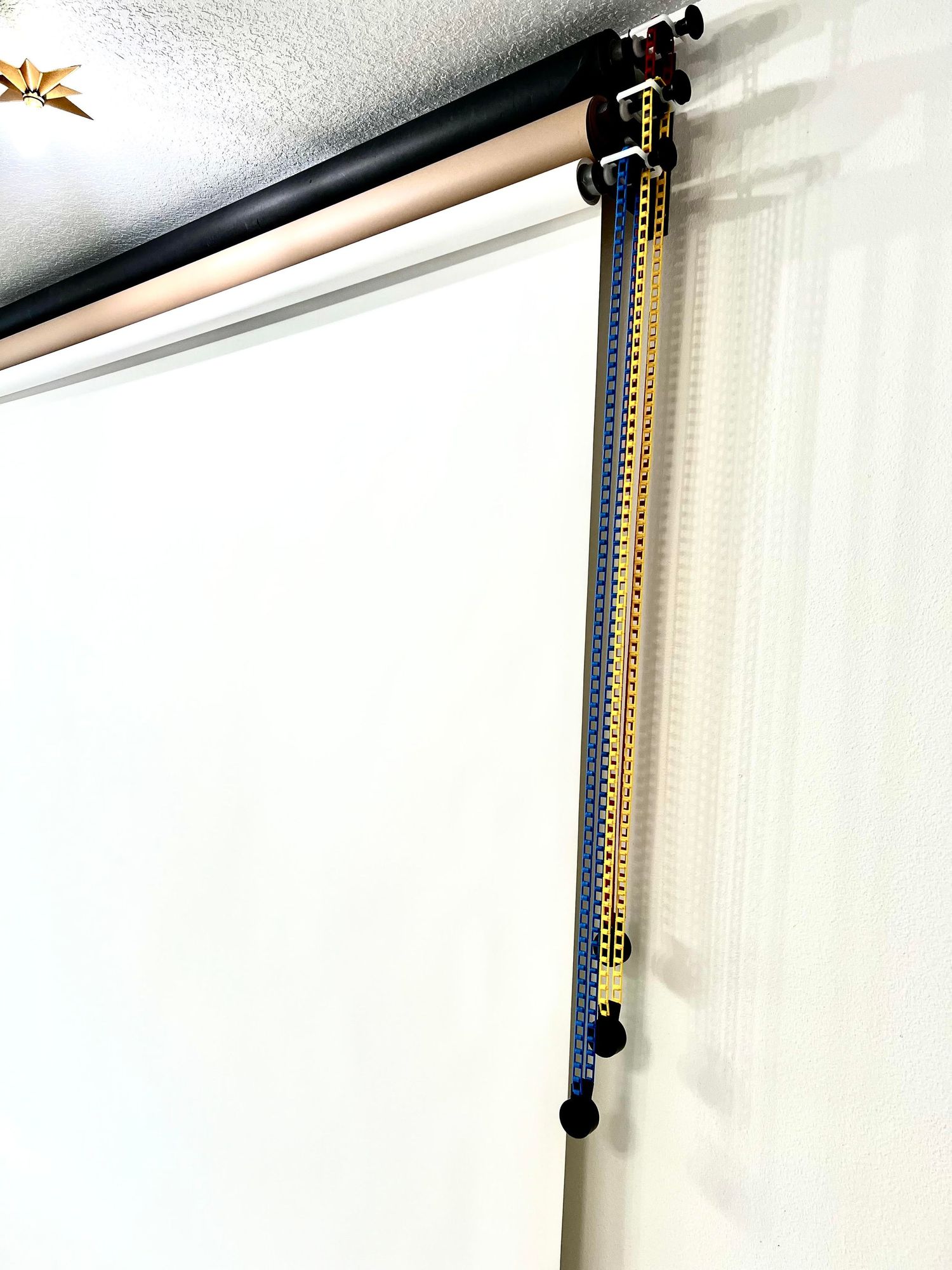 White curtain rod mounted on wall with decorative gold butterfly accents.