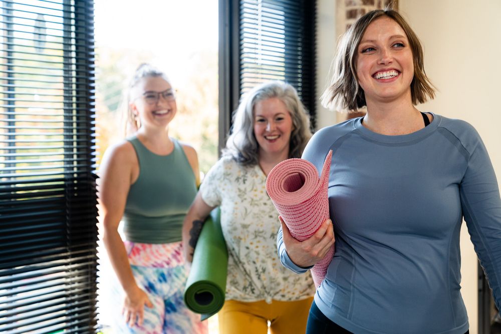 Small group engaged in casual conversation and laughter while taking a break from exercise.