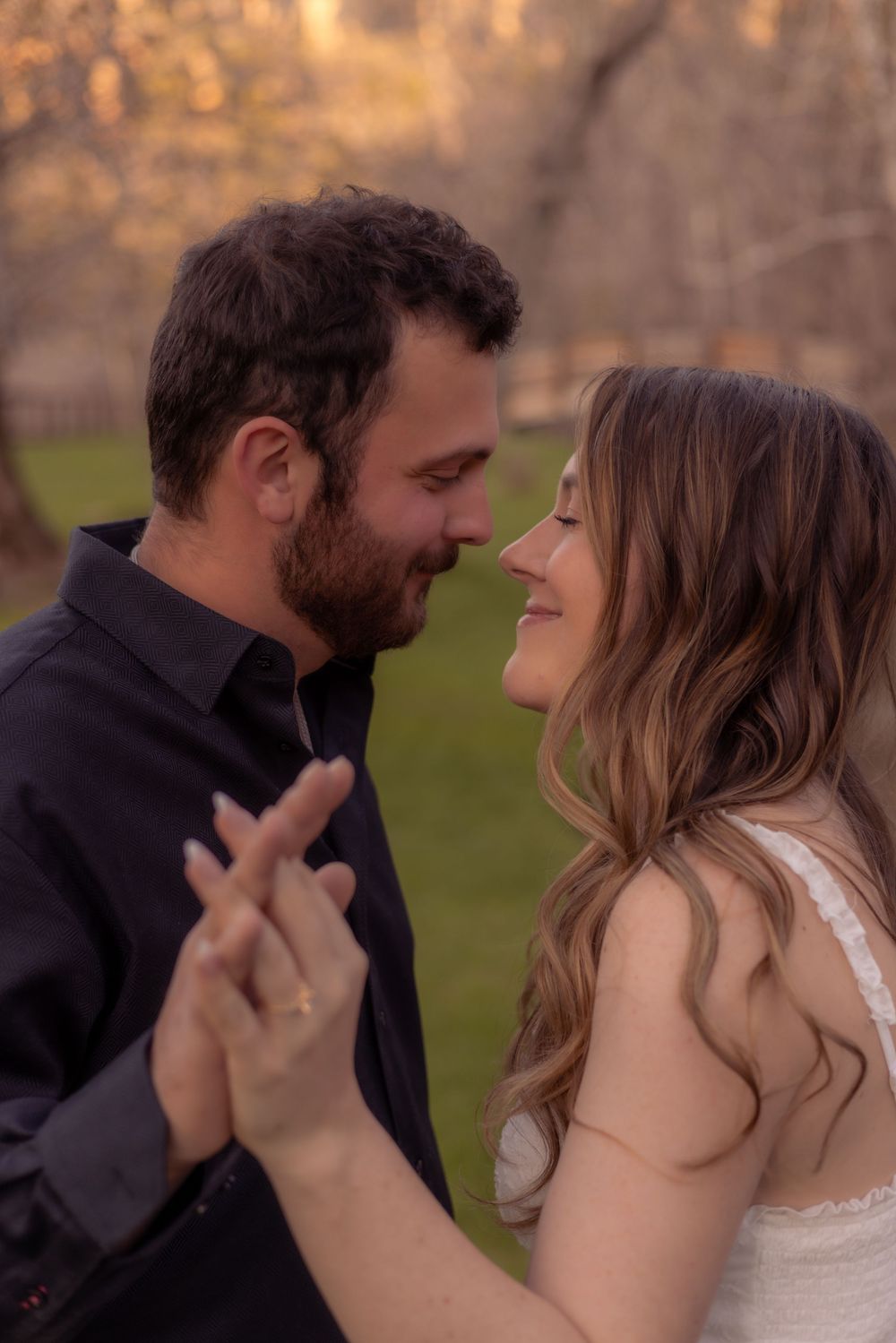 A romantic couple shares an intimate moment during a sunset photoshoot in their casual and formal attire.