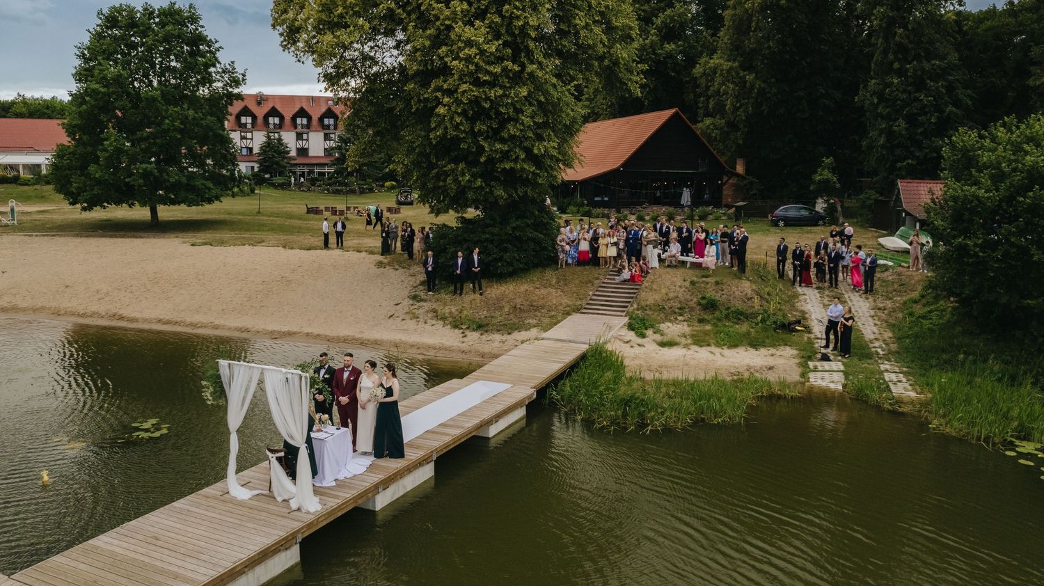 Ślub cywilny czy kościelny. ślub nad brzegiem jeziora na pomoście.. Wojciech Grzegorczyk fotograf ślubny.