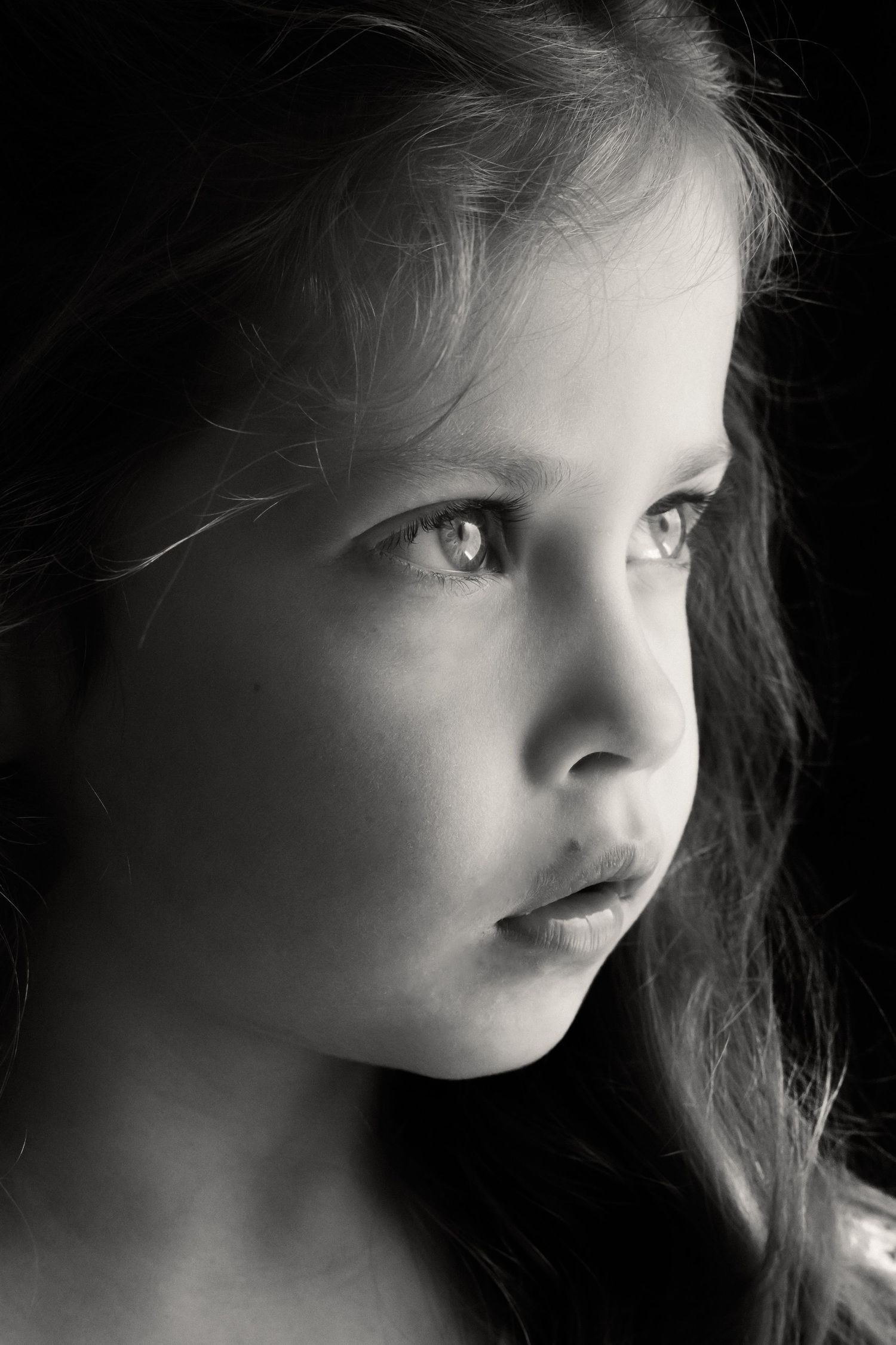 Dramatic black and white profile portrait with soft lighting.