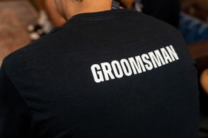 Black t-shirt with white GROOMSMAN text printed on the back.