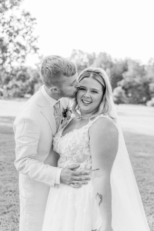 Black and white portrait of newlyweds sharing an intimate moment outdoors.