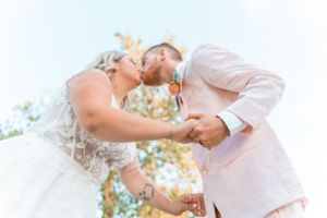Sun-drenched portrait of couple sharing a romantic moment during their wedding celebration.