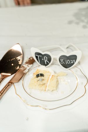 A white plate with deserts and heart-shaped sunglasses displaying initials and a wedding date.