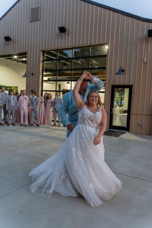 A couple dancing at their wedding celebration outside a modern venue.