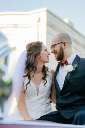 A romantic wedding moment captured in front of a classic white building.