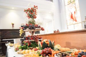 Elegant wedding reception buffet table with floral centerpiece and assorted appetizers.
