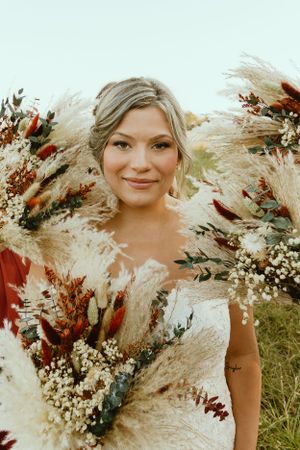 Portrait with dried flowers and pampas grass bouquet in natural outdoor setting.