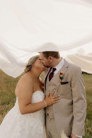 Romantic wedding portrait with flowing veil in gentle breeze.