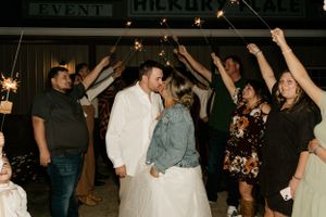 Wedding reception dance party with guests celebrating under dimmed lights.