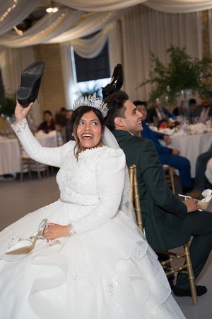 A joyful wedding reception moment showing celebration with a shoe tradition.