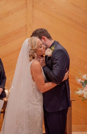 Intimate wedding ceremony moment in a chapel with warm wooden walls.