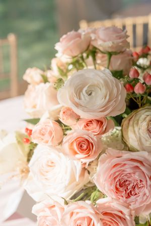 Close-up of a romantic wedding bouquet with pink and white roses in soft natural light.
