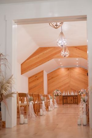 Elegant wedding ceremony venue with vaulted wooden ceilings and geometric crystal chandeliers.