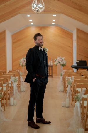 Wedding ceremony setup in an elegant chapel with wooden accents and modern lighting.