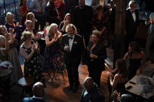 Guests dancing and mingling on a dimly lit dance floor at a formal evening celebration.