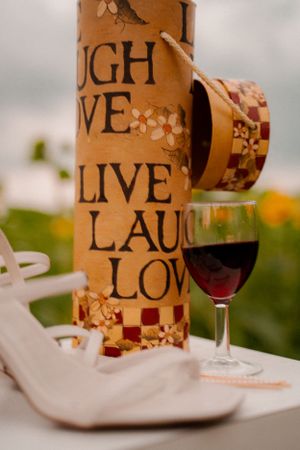 Decorative wine holder with 'Live Laugh Love' text and glass of red wine.