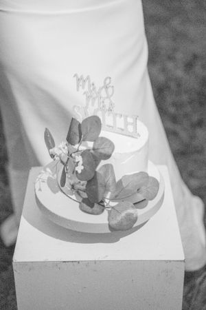 Black and white photo of wedding cake topper with floral decorations.