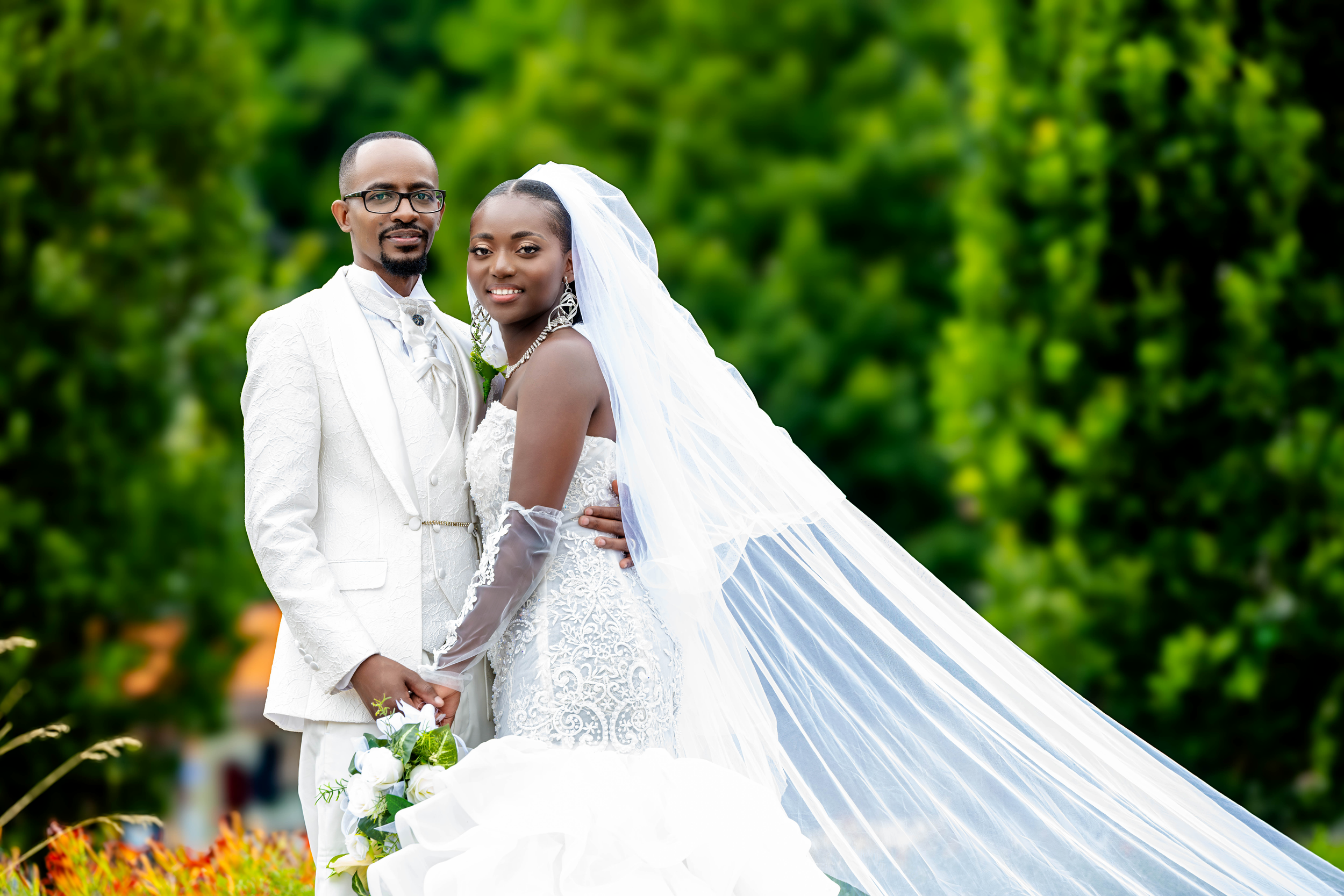 Couple de mariés posant avec élégance en extérieur entouré de verdure, capturé par Payo Studio lors d'une séance photo de mariage.