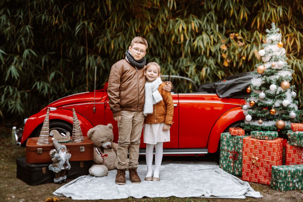 Mini-session photo de Noël 2024 avec une coccinelle VW rouge décorée pour les fêtes, créant une ambiance festive et chaleureuse.