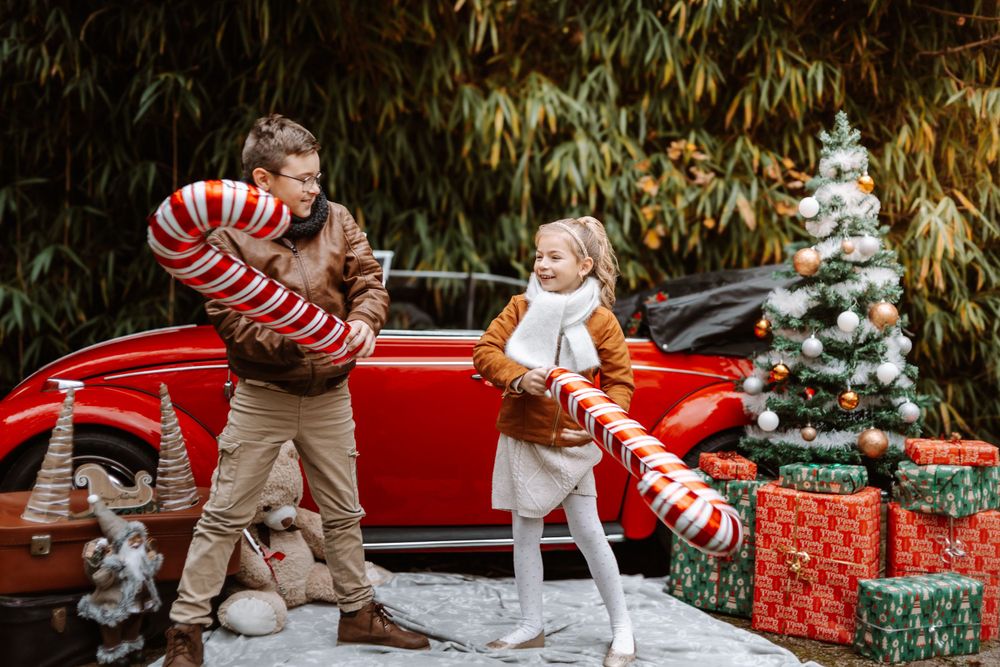 Mini-session photo de Noël 2024 avec une coccinelle VW rouge décorée pour les fêtes, créant une ambiance festive et chaleureuse.
