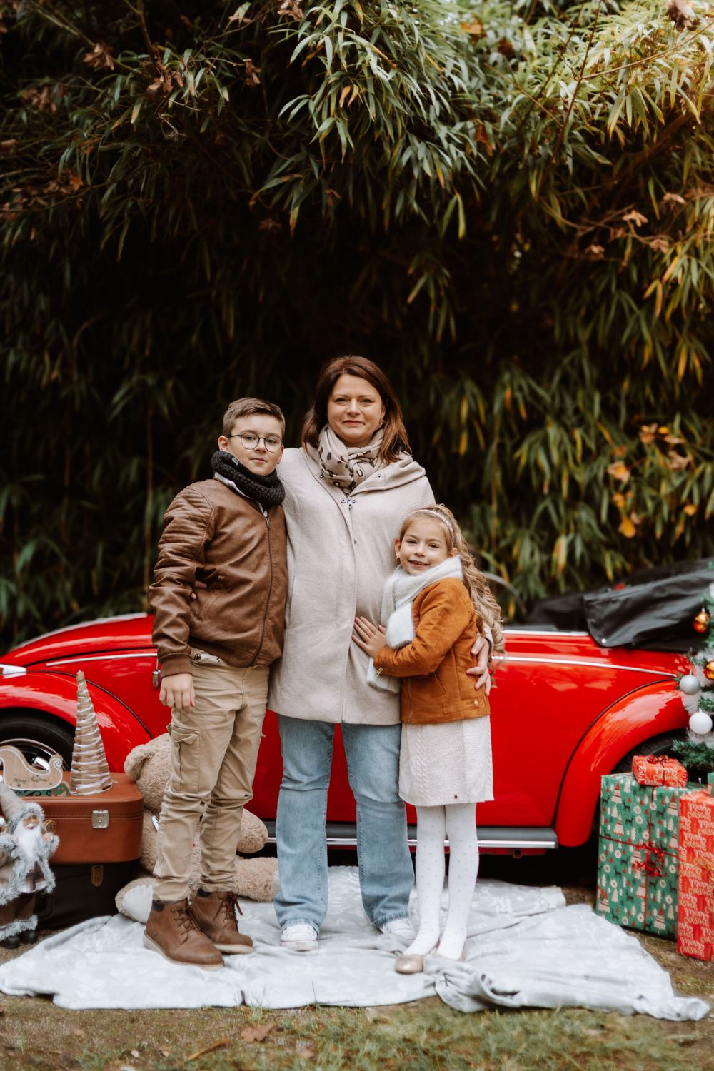 Mini-session photo de Noël 2024 avec une coccinelle VW rouge décorée pour les fêtes, créant une ambiance festive et chaleureuse.