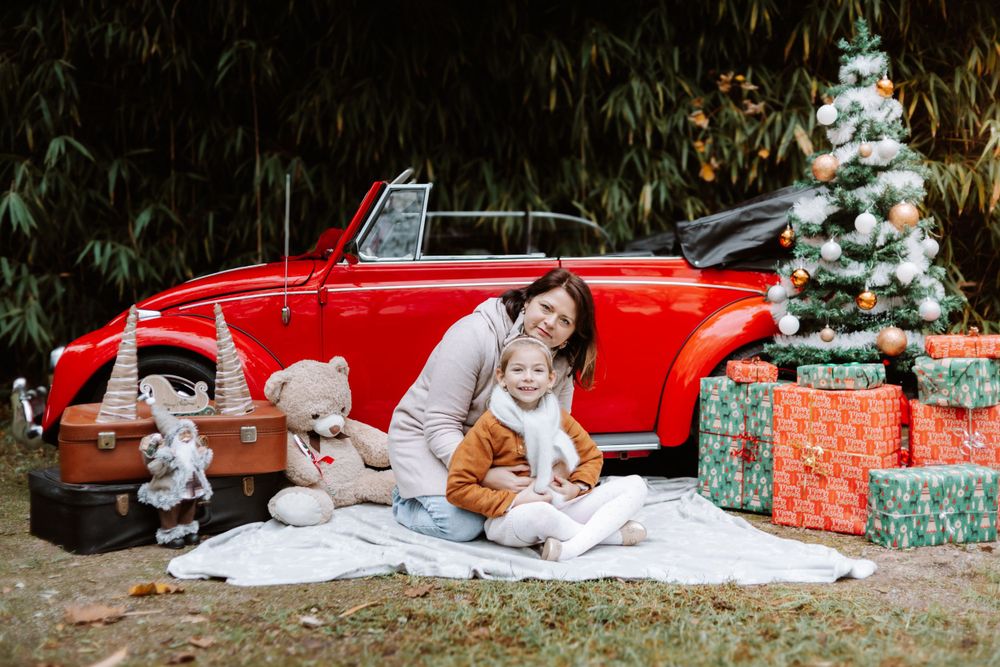 Mini-session photo de Noël 2024 avec une coccinelle VW rouge décorée pour les fêtes, créant une ambiance festive et chaleureuse.