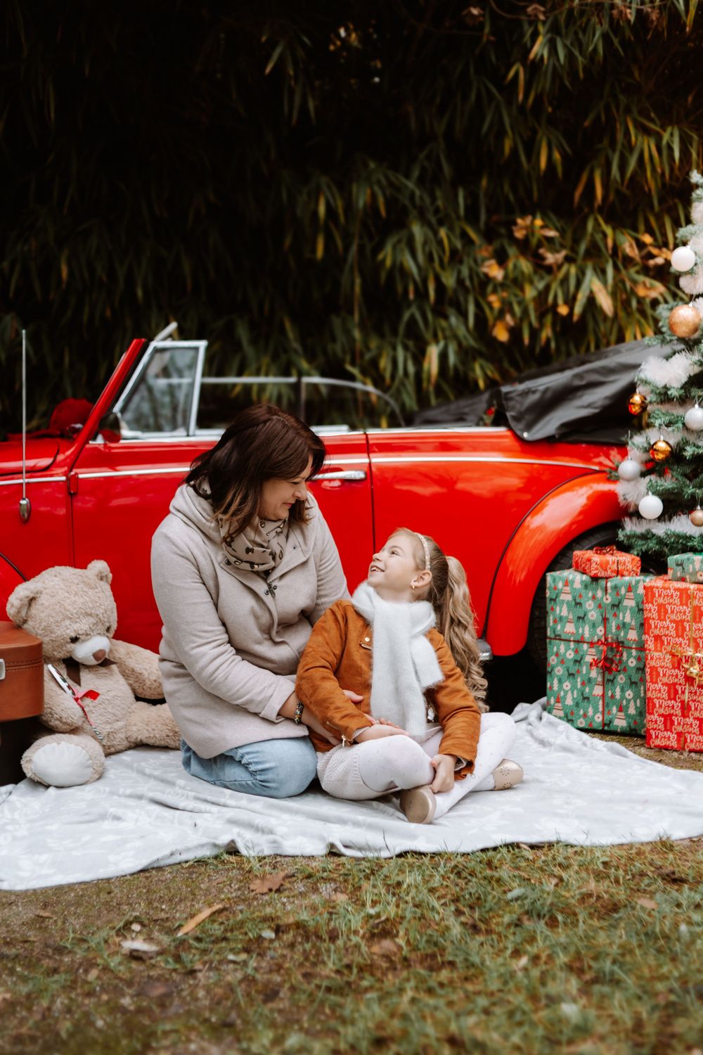 Mini-session photo de Noël 2024 avec une coccinelle VW rouge décorée pour les fêtes, créant une ambiance festive et chaleureuse.