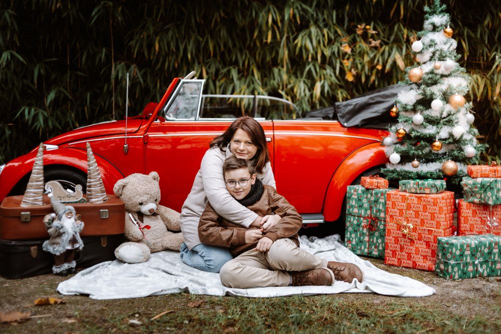 Mini-session photo de Noël 2024 avec une coccinelle VW rouge décorée pour les fêtes, créant une ambiance festive et chaleureuse.