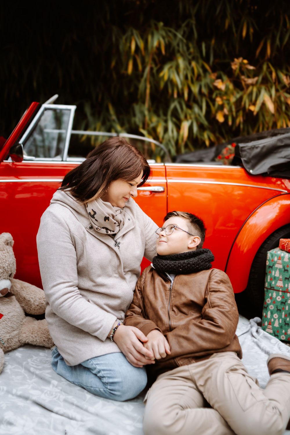 Mini-session photo de Noël 2024 avec une coccinelle VW rouge décorée pour les fêtes, créant une ambiance festive et chaleureuse.