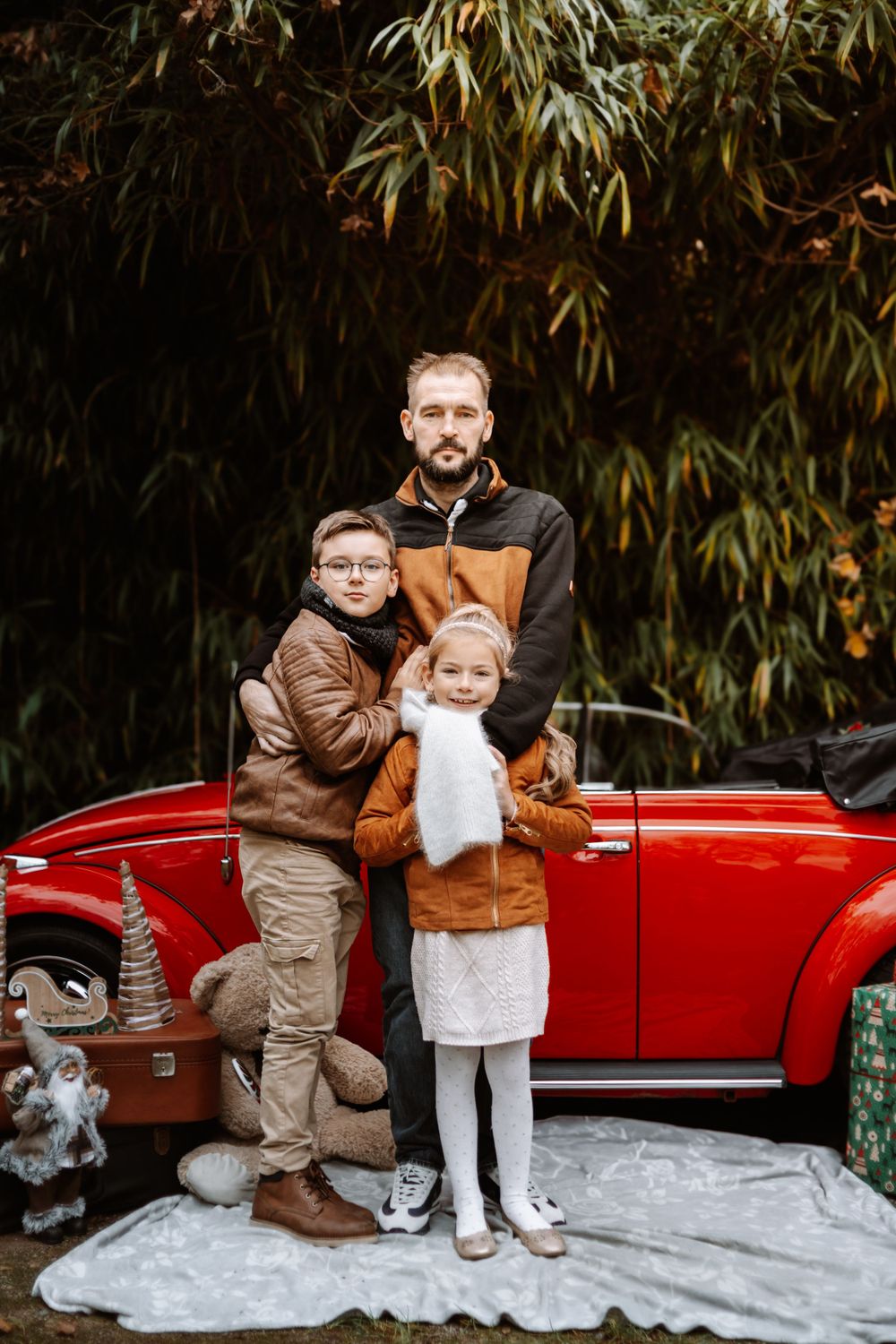 Mini-session photo de Noël 2024 avec une coccinelle VW rouge décorée pour les fêtes, créant une ambiance festive et chaleureuse.