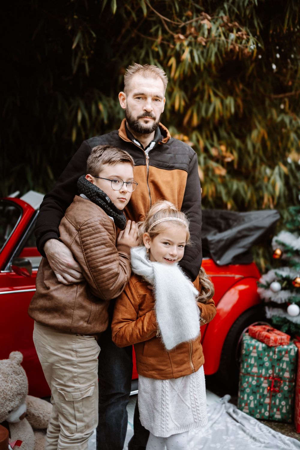 Mini-session photo de Noël 2024 avec une coccinelle VW rouge décorée pour les fêtes, créant une ambiance festive et chaleureuse.