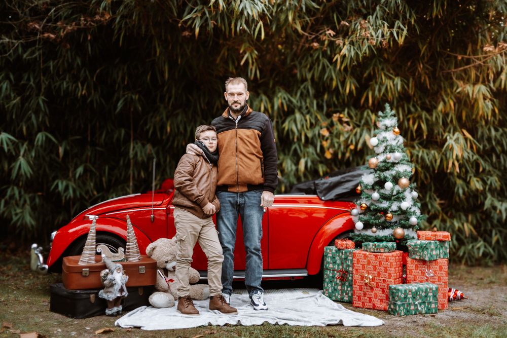Mini-session photo de Noël 2024 avec une coccinelle VW rouge décorée pour les fêtes, créant une ambiance festive et chaleureuse.