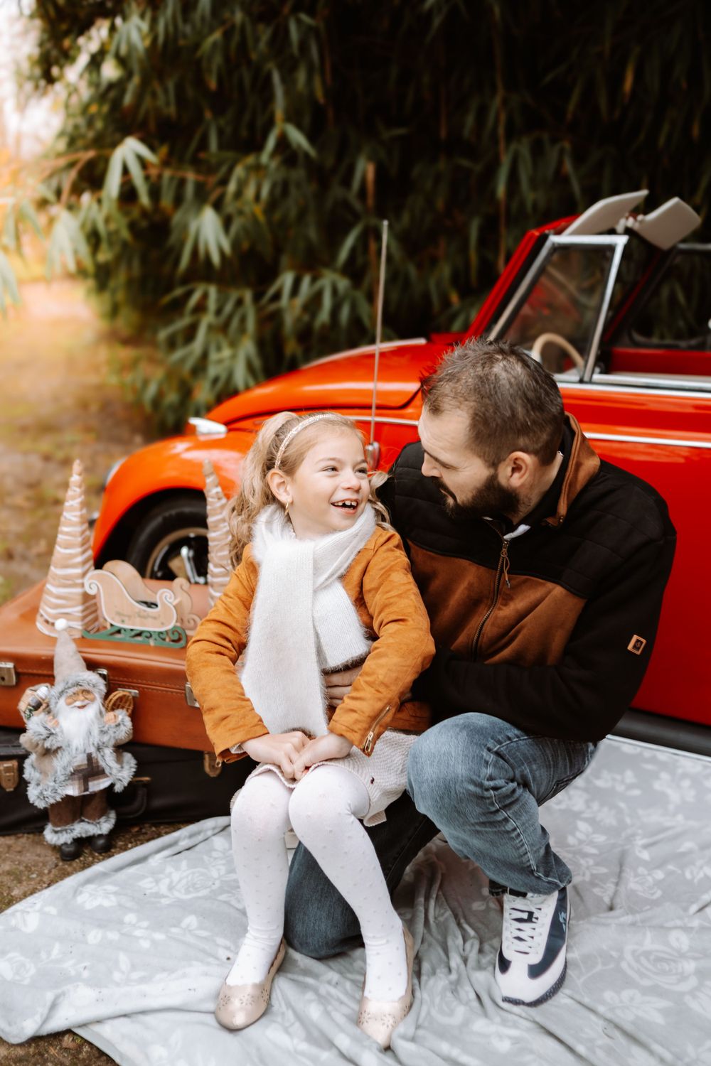 Mini-session photo de Noël 2024 avec une coccinelle VW rouge décorée pour les fêtes, créant une ambiance festive et chaleureuse.