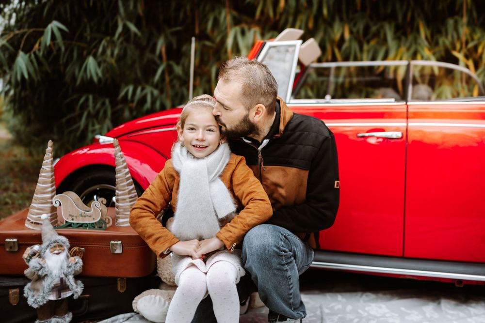 Mini-session photo de Noël 2024 avec une coccinelle VW rouge décorée pour les fêtes, créant une ambiance festive et chaleureuse.