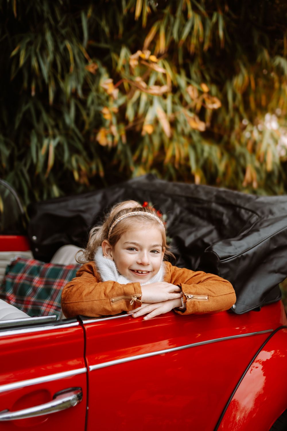 Mini-session photo de Noël 2024 avec une coccinelle VW rouge décorée pour les fêtes, créant une ambiance festive et chaleureuse.