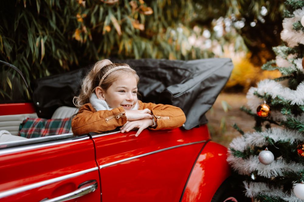 Mini-session photo de Noël 2024 avec une coccinelle VW rouge décorée pour les fêtes, créant une ambiance festive et chaleureuse.